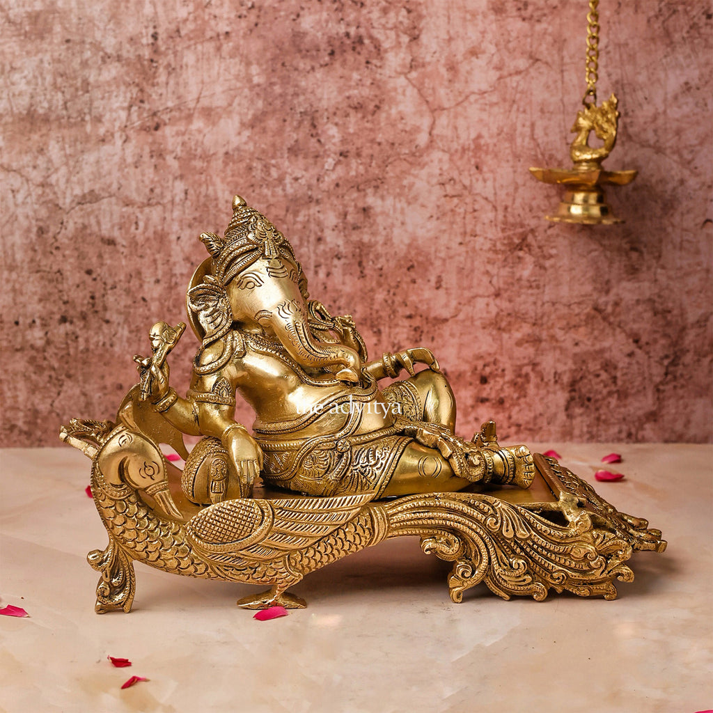 "Front view of 7-inch Ganesha Idol in Brass resting on a peacock couch"