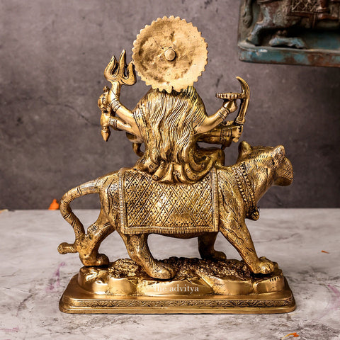 Back view of brass Durga Mata Murti riding lion on base, highlighting detailed carving of Durga’s hair, attire, and the lion’s mane.