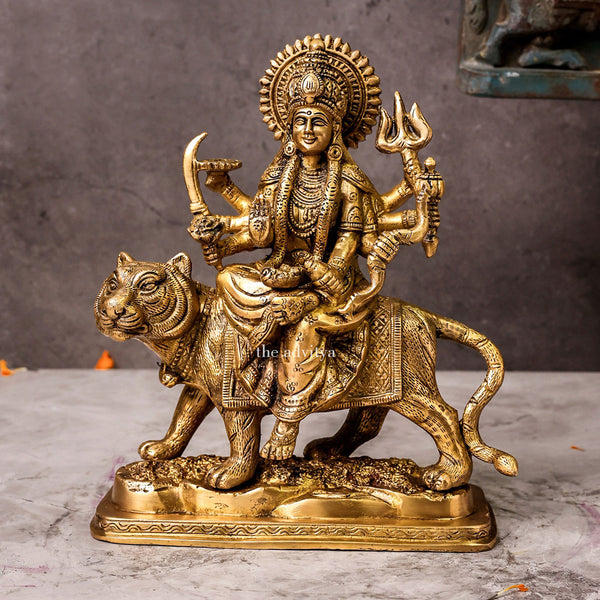 Front view of brass Durga Mata Murti riding a lion on a base, showcasing eight arms holding traditional weapons, with intricate detailing and regal expression