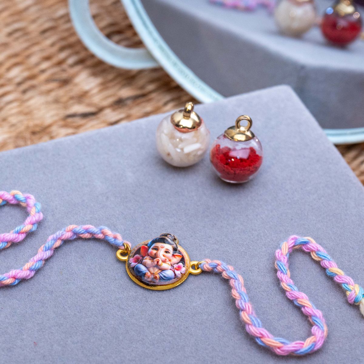 Kids Bal Ganesha Rakhi in Coral & Thread With Roli Chawal