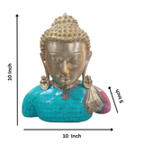 Close up view of brass Buddha idol bust showing turquoise and red stones