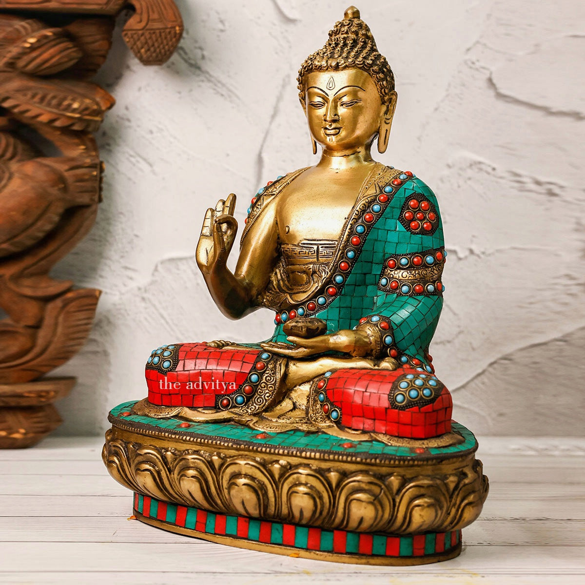 Left angle view of a brass Buddha Murti in colorful mosaic work.
