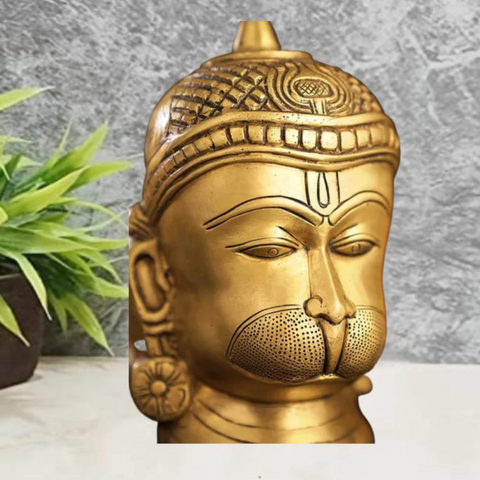 Side angle view of brass engraved Hanuman statue highlighting engraved ornaments and sculpted ears
