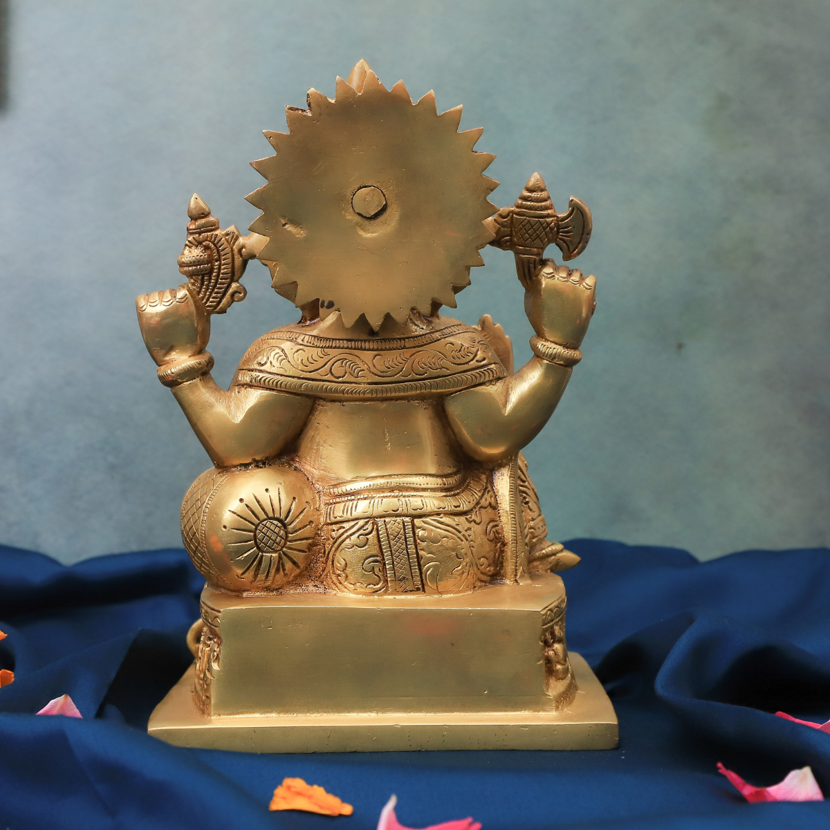 Back view of brass Ganesha statue highlighting four hands and detailed rear carving