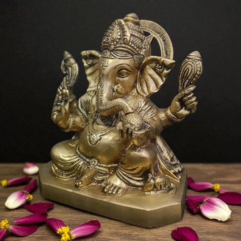 Close-up of brass Ganesha statue with Shankh showing fine detailing and polished brass work.
