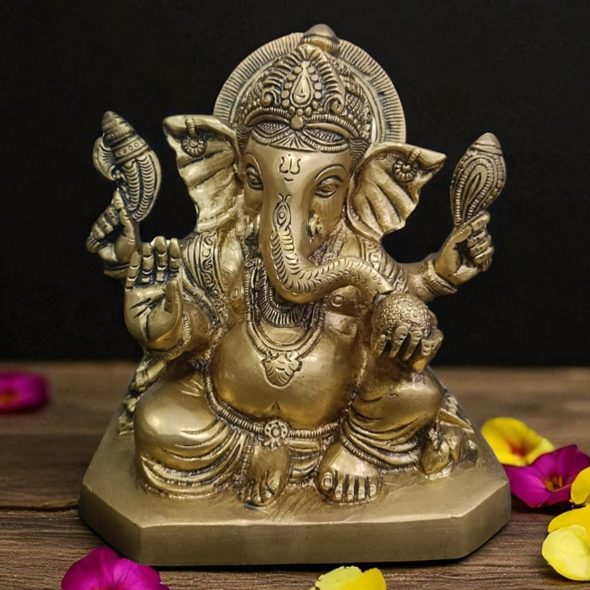 Front view of brass Ganesha statue with Shankh in hand in sitting posture, 7.5 inch