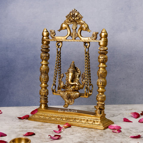 Side angle of 10-inch Brass Ganpati Idol resting on Jhula swing with detailed craftsmanship, perfect for home or Mandir décor.