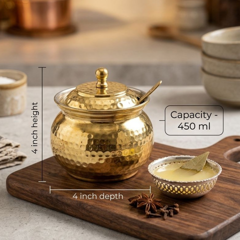 Brass spoon pouring ghee from hammered Dimension detail