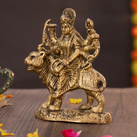 Brass Durga idol on lion, left side profile highlighting intricate carvings on lion’s mane and Durga’s multiple arms.