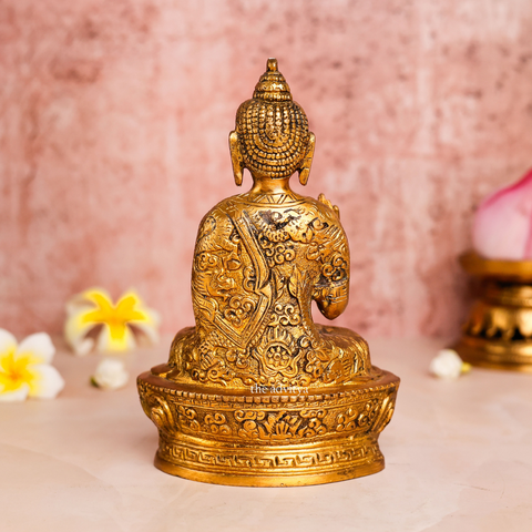 Left angle view of brass handcarved Buddha Murti highlighting detailed robe carvings and peaceful posture back view.