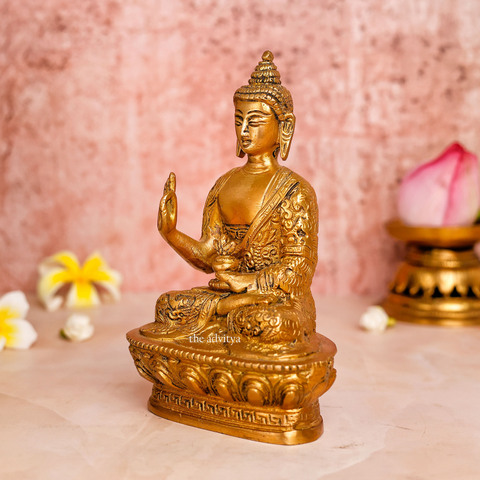 Left angle view of brass handcarved Buddha Murti highlighting detailed robe carvings and peaceful posture