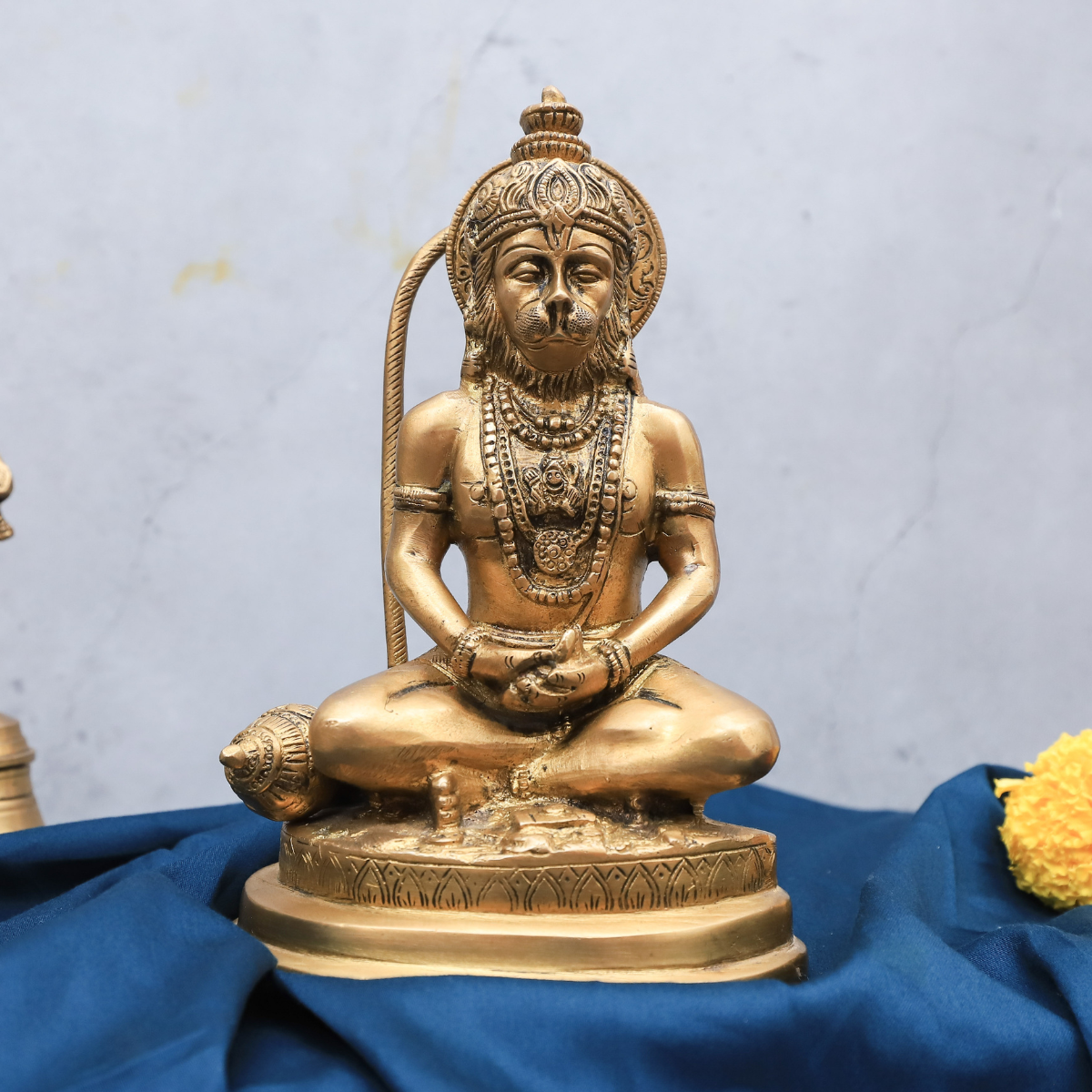 Close-up of brass Hanuman statue highlighting meditating mudra details
