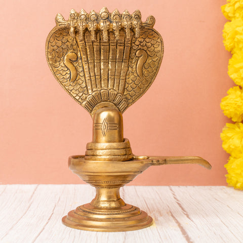 Brass shivling with a seven-headed snake on the right side angle.