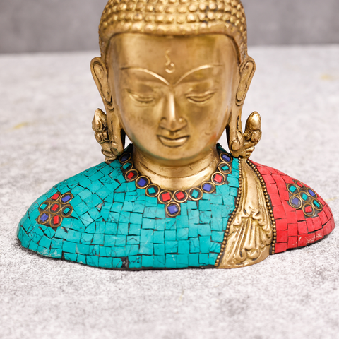 Close face of brass Tibet Buddha sculpture with detailed stone work