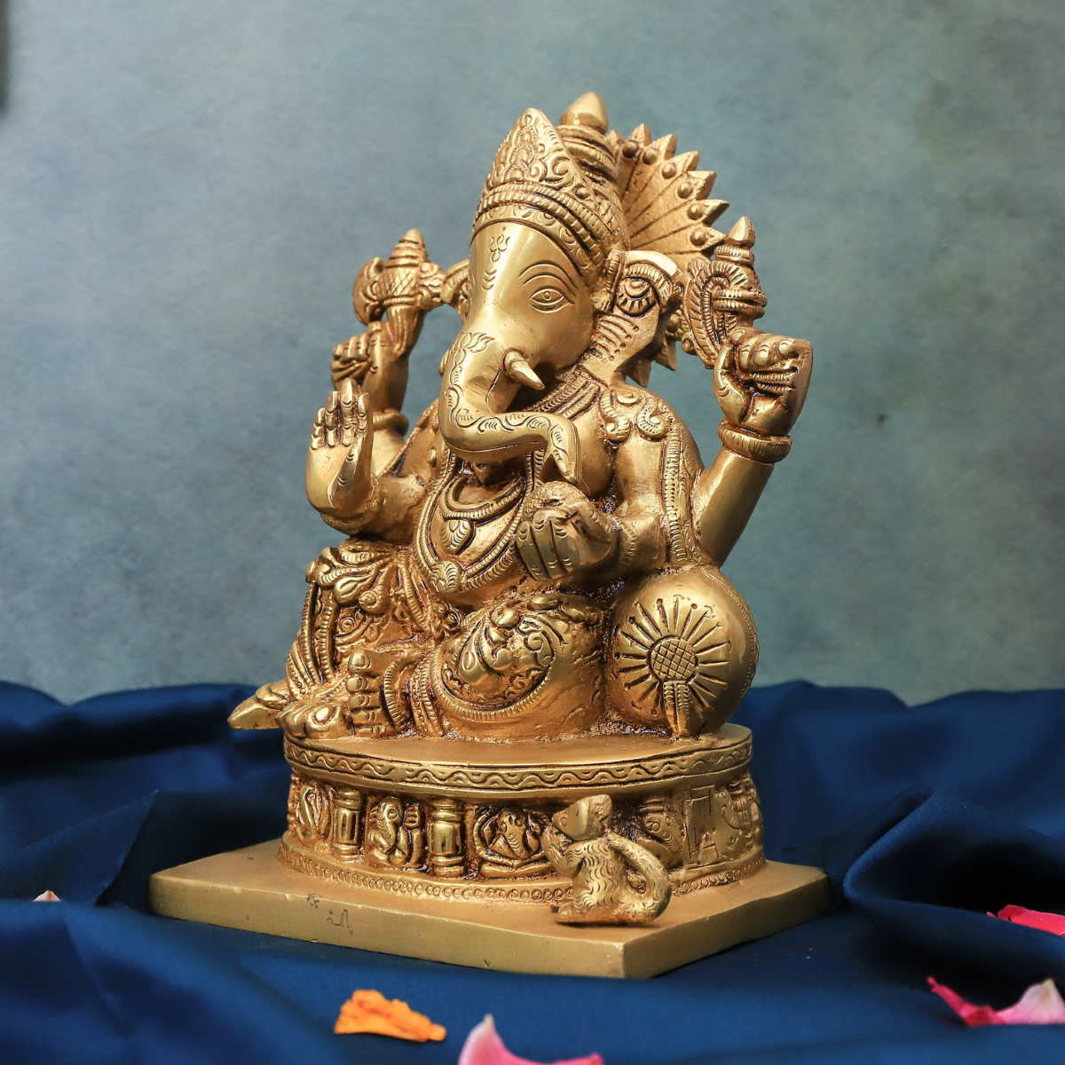 Angled view of brass Vinayaka Ganesha idol showing four hands and detailed craftsmanship