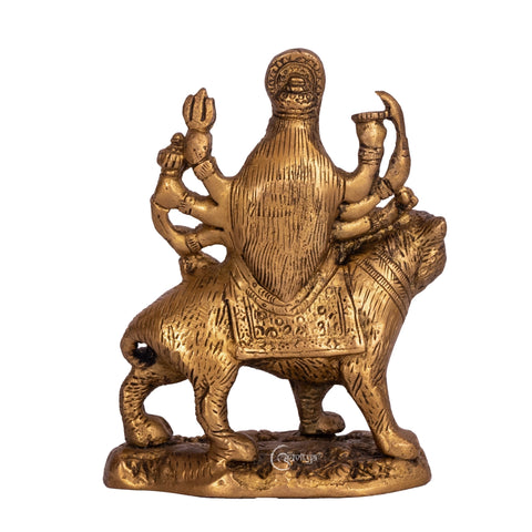 Brass Durga statue sitting on lion, rear view showing detailed craftsmanship of Durga’s hair, ornaments, and lion’s tail.
