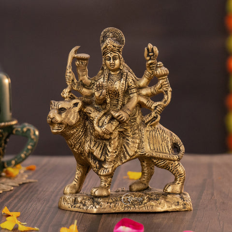 Brass Goddess Durga statue sitting on lion, front view showing detailed face, ornaments, and raised weapons.