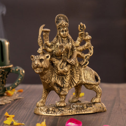 Brass Goddess Durga murti riding lion, right side view displaying flowing attire and weapon details.