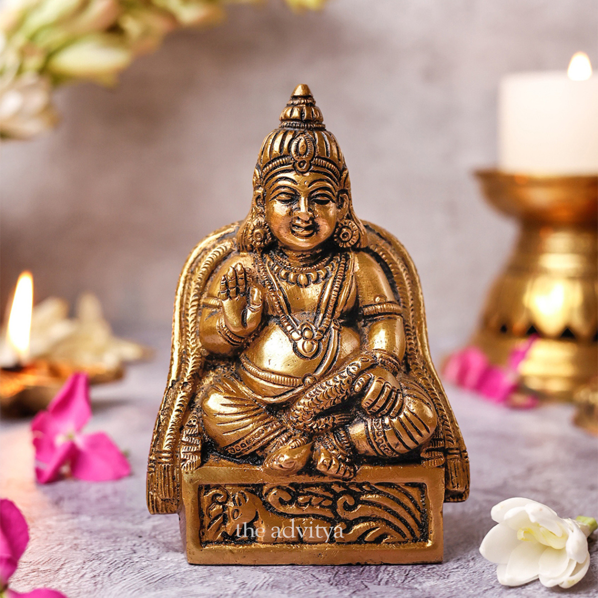 Front view of Kuber idol in sitting pose on decorative base.