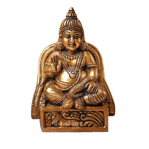 Close-up of Kuber idol holding wealth symbols with fine detailing.