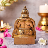 Back detailing of Lord Kuber idol showing smooth brass finish.