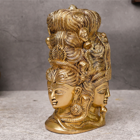 Left angle view of brass Lord Shiva statue with three faces behind Parvati.