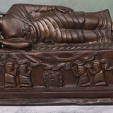 Close-up view of antique brass reclining Buddha statue with traditional design