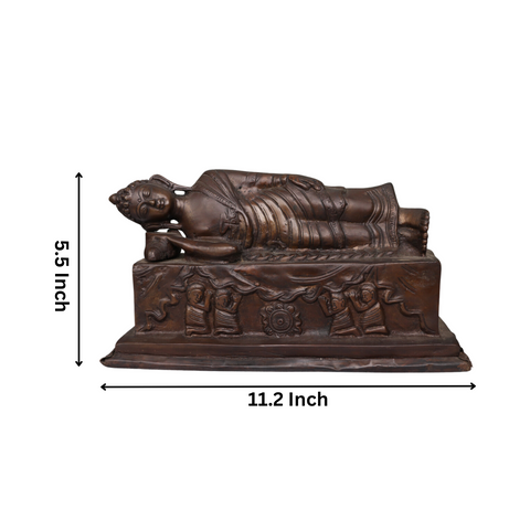 brass sleeping Buddha statue highlighting intricate robe and base carvings.