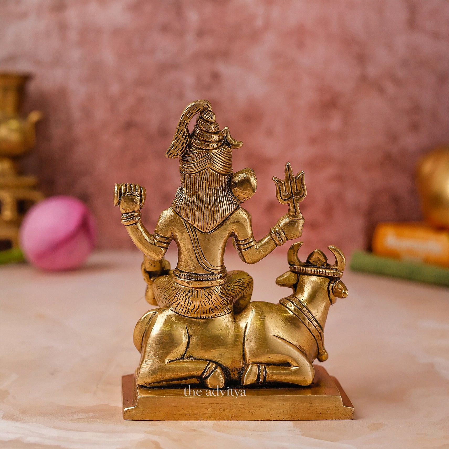Back view of a small brass Lord Shiva idol with Nandi in seated form
