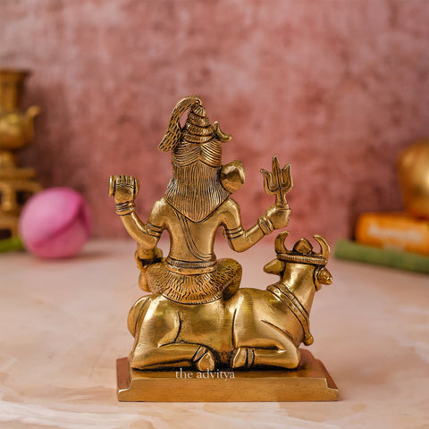Back view of a small brass Lord Shiva idol with Nandi in seated form