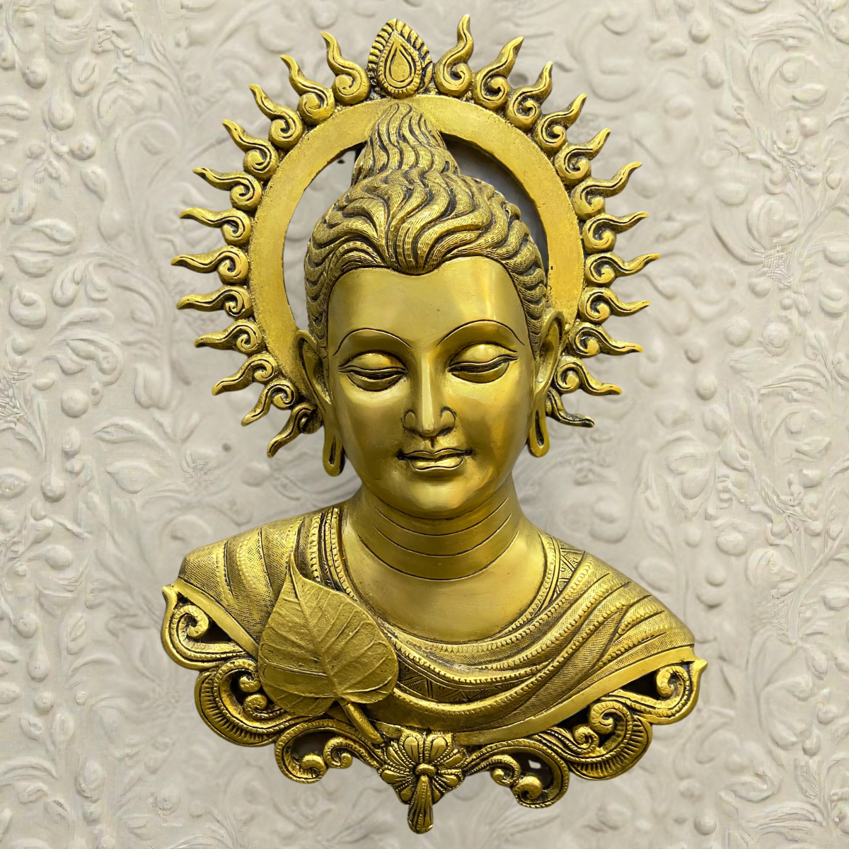 Close-up of Tibetan brass Buddha wall hanging with fine detailing.