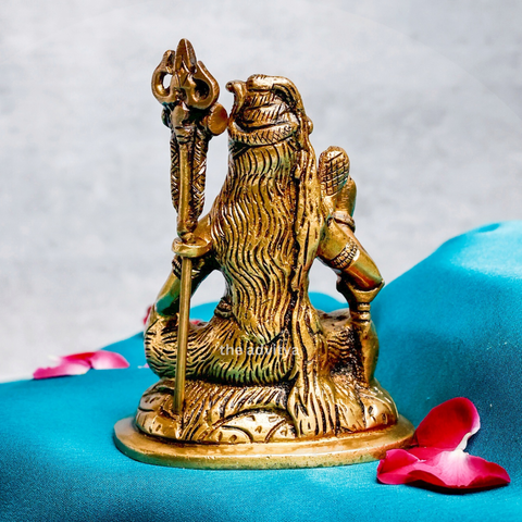 Back view of a traditional brass Shiva statue with a seated posture