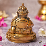 Brass back view of Kubera Statue sitting on base with detailed finishing