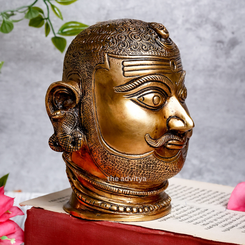 Right side angle of brass Shiva Head highlighting crescent moon design.