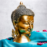 Left angle view of a large brass Buddha head for peaceful living spaces.