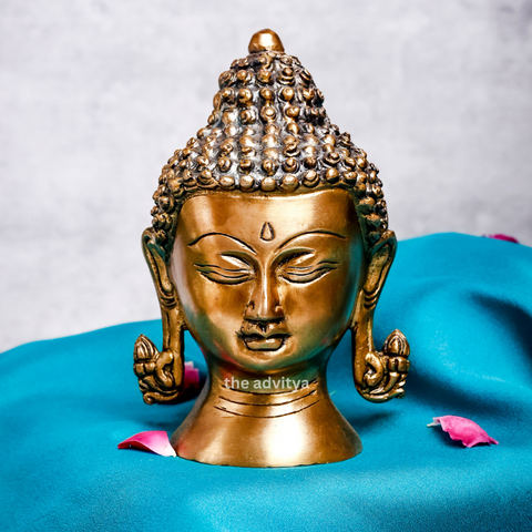 Front view of a small Buddha head statue with a calm and peaceful expression.